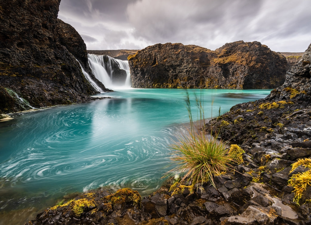 Beautiful view of the cliffs with a waterfall in the Highland region