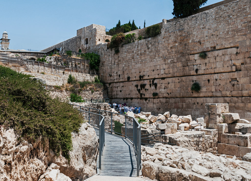the southern section of the kotel western wall of the second temple showing people praying in the egalitarian section among the rubble from the roman destruction of Jerusalem