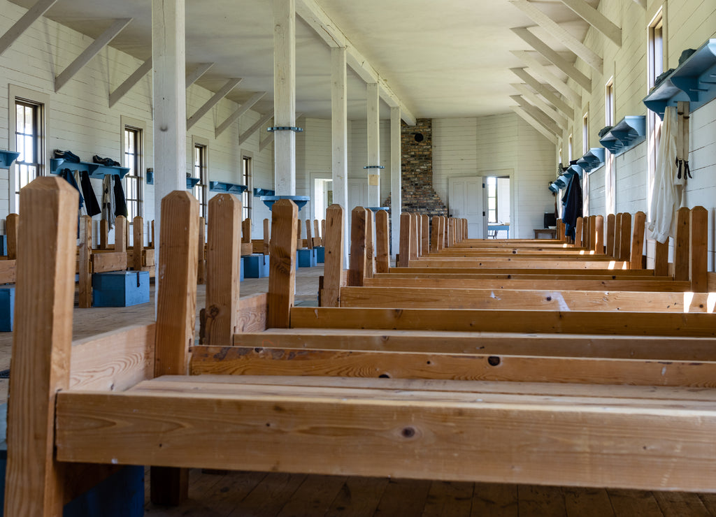 Wooden cots line the wall of a replica soldier barracks at Fort Lincoln, Bismarck, North Dakota