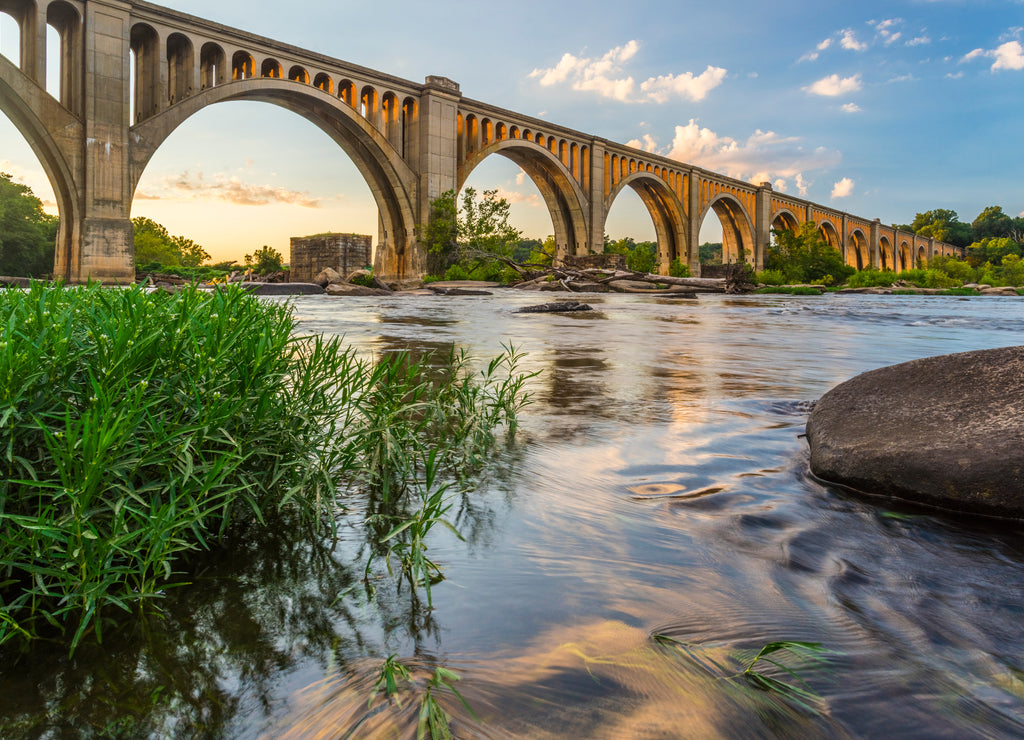 Richmond Railroad Bridge Lit by Sun/ The graceful arches of a railroad bridge spanning the James River in Virginia are illuminated by the setting sun