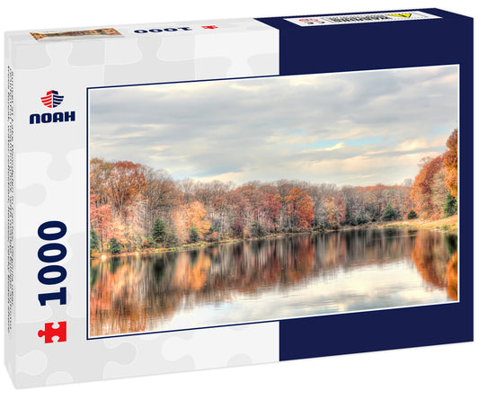 Sunset at Lake Woodglen in Fairfax, Virginia near residential neighborhood, with orange foliage autumn trees forest, water reflection, houses, rocky beach shore