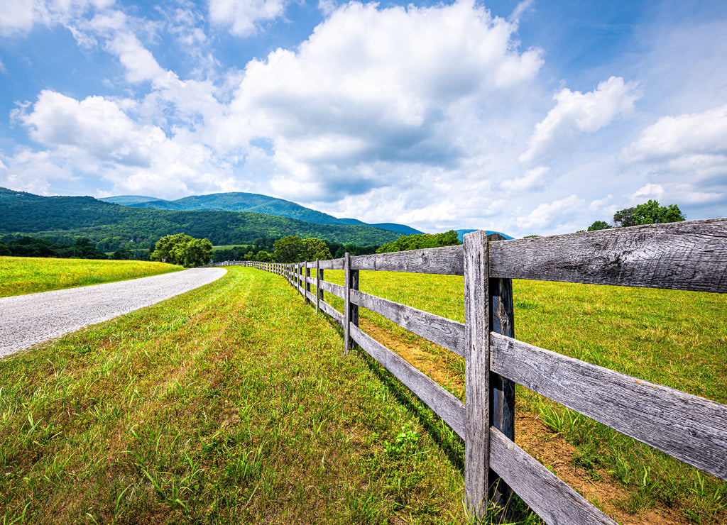 Farm road fence closeup in Roseland, Virginia near Blue Ridge parkway mountains in summer with idyllic rural landscape countryside in Nelson County