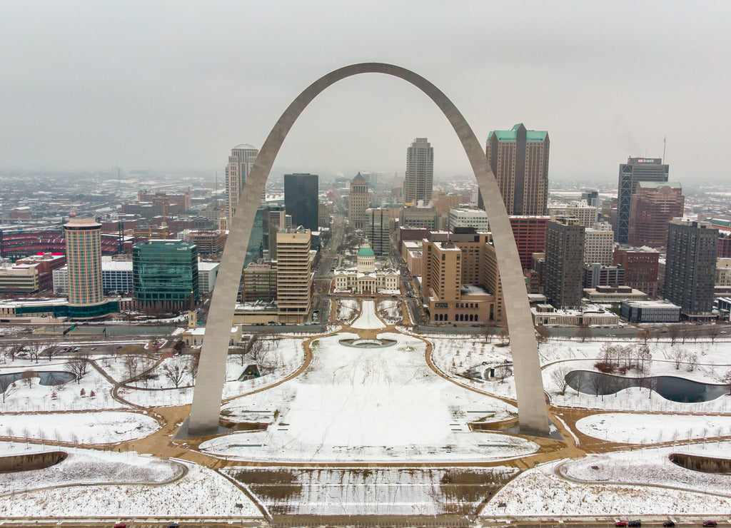 St Louis, Missouri \ USA: Aerial view of a downtown covered in snow behind Gateway Arch. Old courthouse, The Basilica Of Saint Louis, and a Busch stadium on a winter day