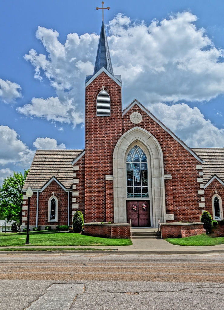 Vertical shot of a church at Cole Camp, Missouri with a cloudy blue sky in the background