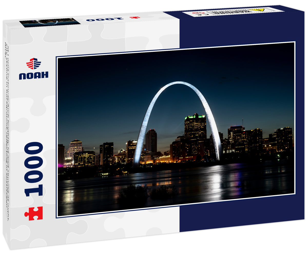 St Louis Gateway Arch brightly lit and shining at night, city skyline in background, reflecting in Mississippi River