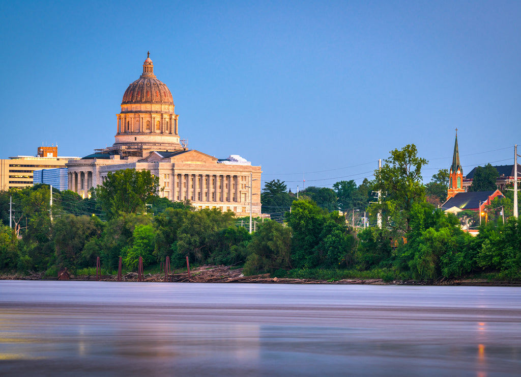 Jefferson City, Missouri, USA downtown view on the Missouri River with the State Capitol at dusk