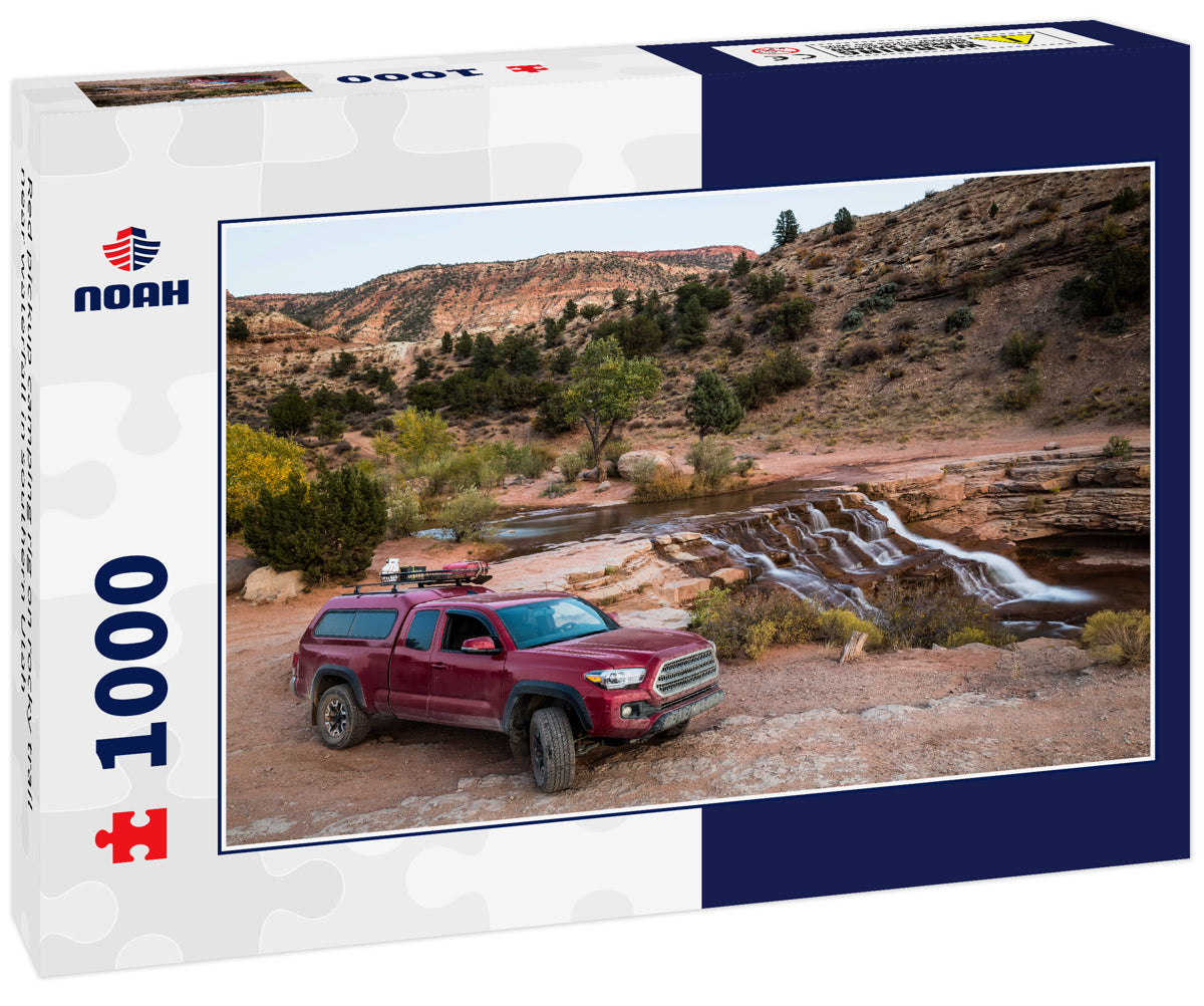 Red pickup camping rig on rocky trail near waterfall in southern Utah