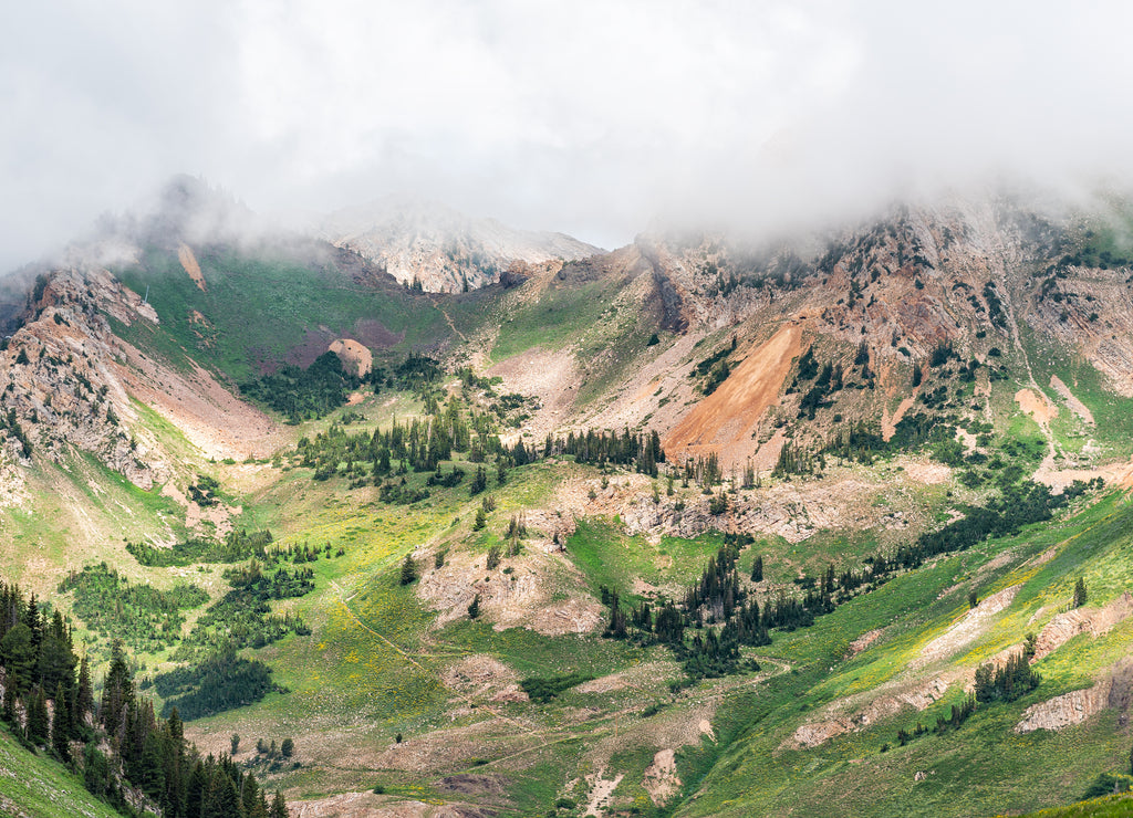 Albion Basin, Utah summer cloudy morning in 2019 with clouds on stormy day and mist fog covering blanketing rocky Wasatch mountains