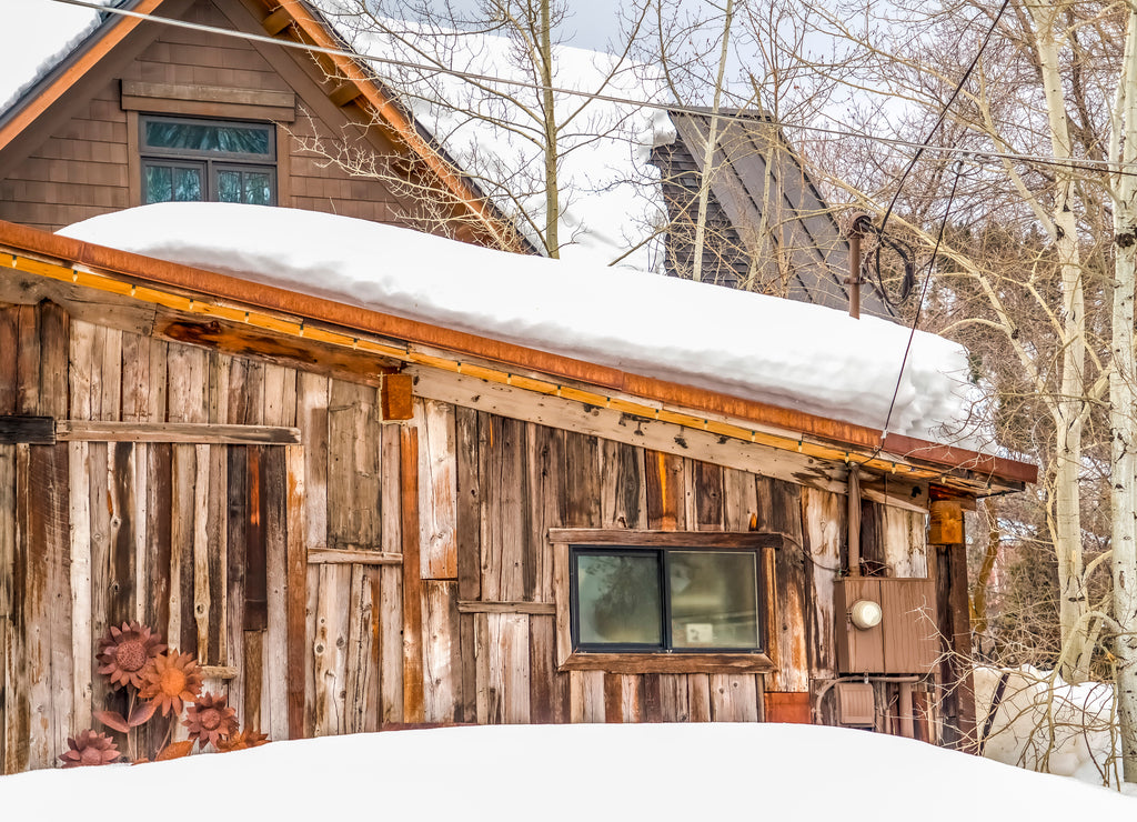 Rustic cabin with brown wooden walls in Park City Utah mountain in winter