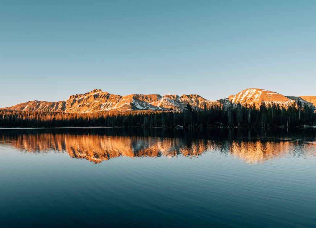 Snowy mountains reflecting in Mirror Lake, in the Uinta Mountains, Utah