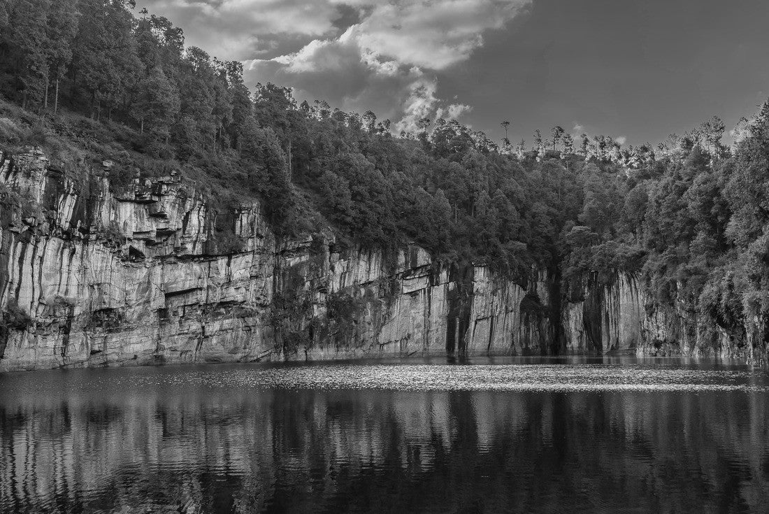 A beautiful emerald lake in the crater of an extinct volcano is surrounded by steep cliffs. Coniferous forest on the banks. Reflection on calm water. Clouds in the blue sky. Tritriva lake. Madagascar 2000pc PuzzleBlack and White