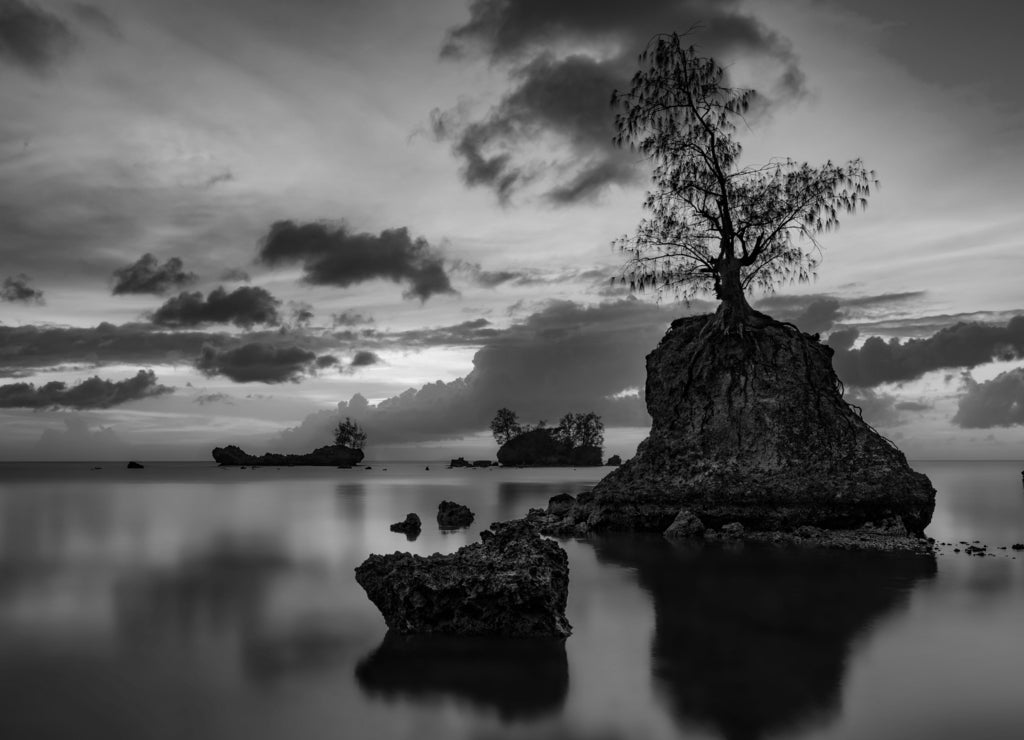 Landscape of a lake with long exposure during a breathtaking sunset in Apaca Point, Guam in black white