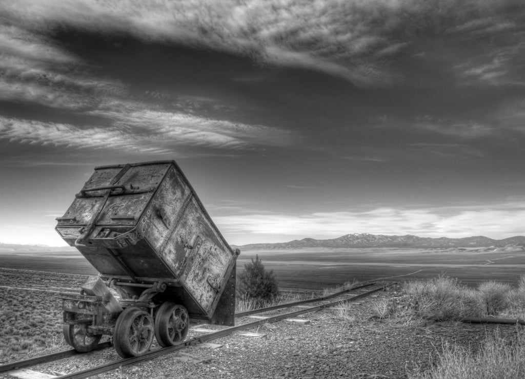 An old mining ore cart on tracks at Berlin, Nevada in black white