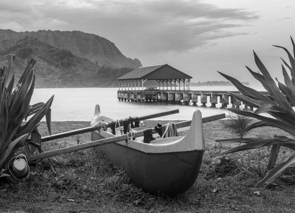 Hawaiian canoe by Hanalei Pier in black white