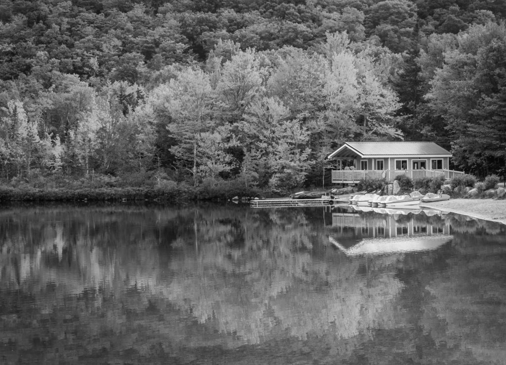 Boathouse and fall colors reflecting in Echo Lake, in Franconia, New Hampshire in black white