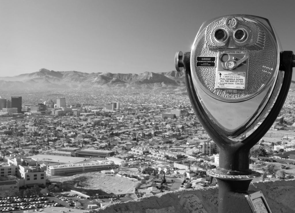 Long range binoculars for tourists and panoramic view of skyline and downtown of El Paso Texas looking toward Juarez, Mexico in black white