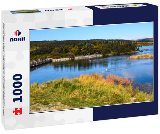 Peaceful landscape at Naknek Lake, Alaska, with glacial blue water, fall color, and cloudy white and blue sky