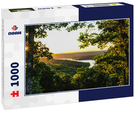 Peaking thru the trees as the sun is starting to rise over the mountains and a cove on Norfork Lake in Mountain Home, Arkansas