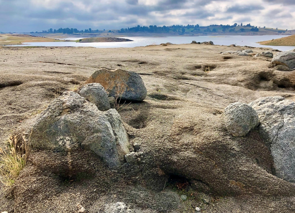 Rocks, grasses, and low water level are seen during drought conditions at millerton lake state park near friant, fresno county, california