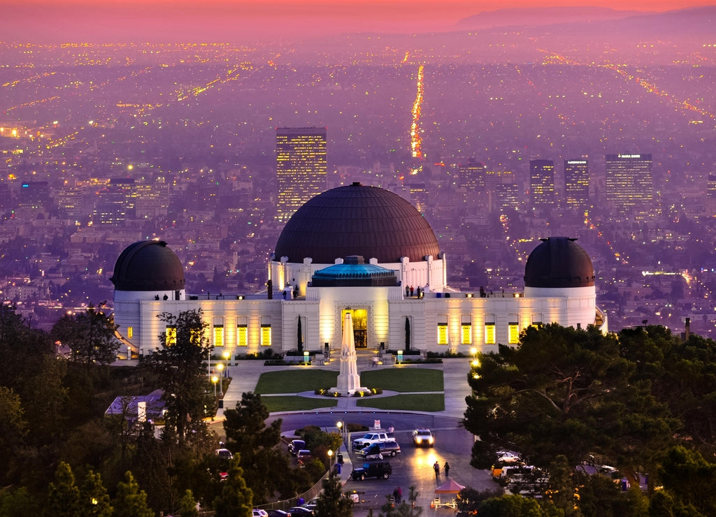 Historic famous Griffith Park Observatory at Sunset with Los Angeles city lights sparkling in background and Catalina Island in distance