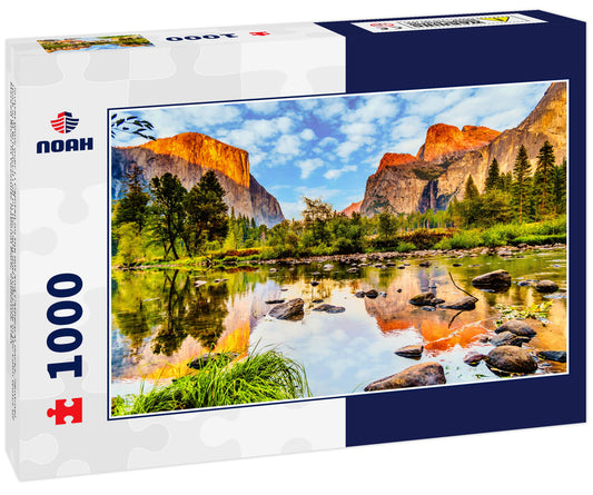 Sunset glow over El Capitan on the left and Cathedral Rocks, Sentinel Rock and Bridalveil Fall on the right and reflecting in the calm water of Merced River in Yosemite National Park, California, USA