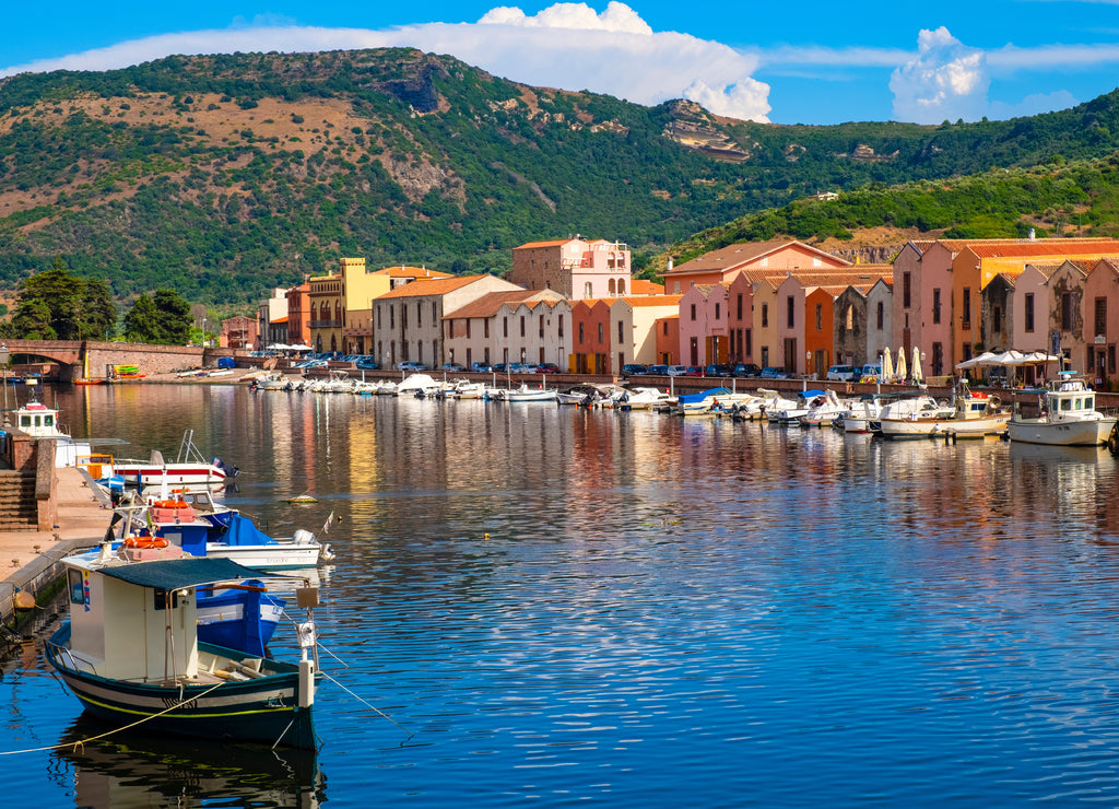 Bosa, Sardinia, Italy - Panoramic view of the old town quarter of Bosa by the Temo river embankment with colorful tenement houses and boats