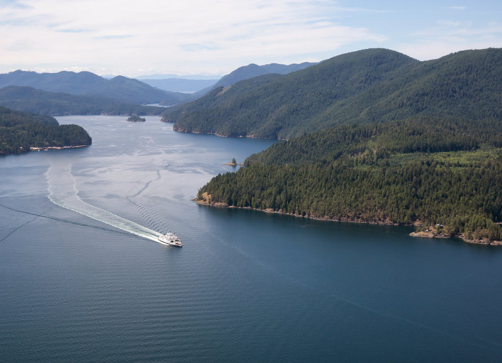 Ferry traveling between the islands during a sunny summer day. Taken in Sunshine Coast, BC, Canada