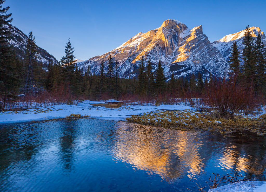 Mount Kidd, a mountain in Kananaskis in the Canadian Rocky Mountains, Alberta, Canada and the Kananaskis River in winter