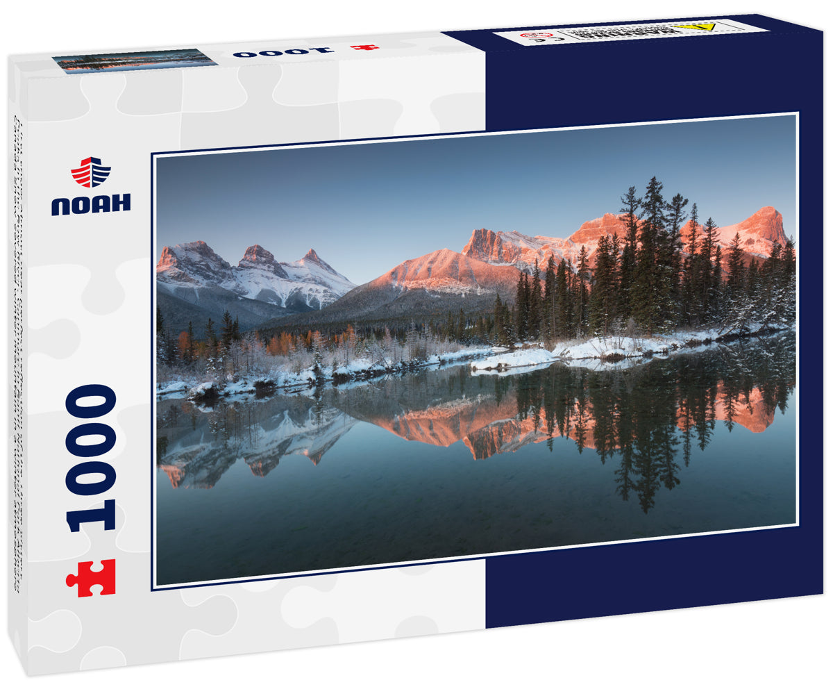 First snow Almost near perfect reflection of the Three Sisters Peaks in the Bow River. Canmore in Banff National Park Alberta Canada Snow-covered winter mountain in a winter atmosphere