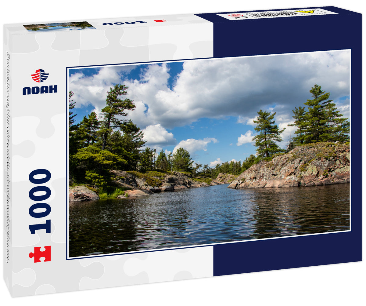 Rocks, trees, blue sky, white clouds and water on a summer day on the Bad River in Ontario, Canada