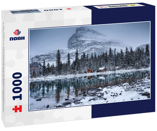 Lake O'hara with wooden hut and snow covered in pine forest on gloomy day at Yoho national park