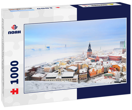 Panoramic view of the Riga old town and Daugava river from St. Peter's Church on a clear winter day. Morning fog and snow-covered houses. Latvia