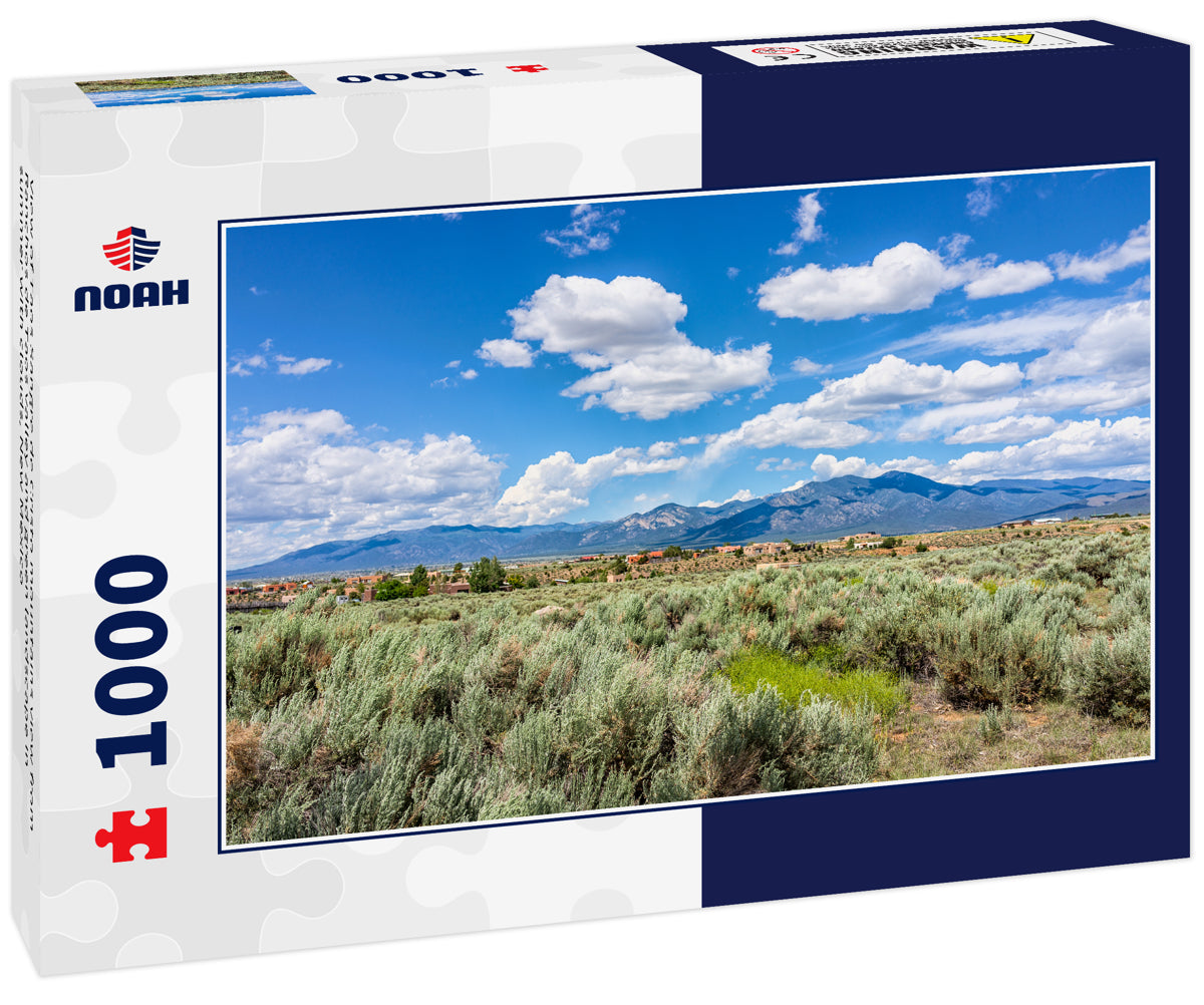 View of Taos Sangre de Cristo mountains view from Ranchos de Taos valley and green landscape in summer with clouds, New Mexico