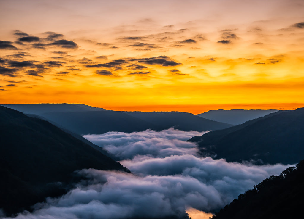 Mountains landscape clouds foggy mist in morning above new river gorge valley in Grandview Overlook, West Virginia during morning colorful sunrise