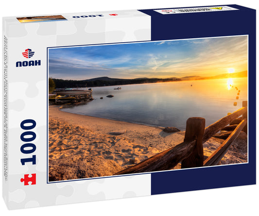 Mist rises from Merrymeeting Lake, as seen from the beach by the marina boat launch, New Durham, New Hampshire right after sunrise on a summer morning