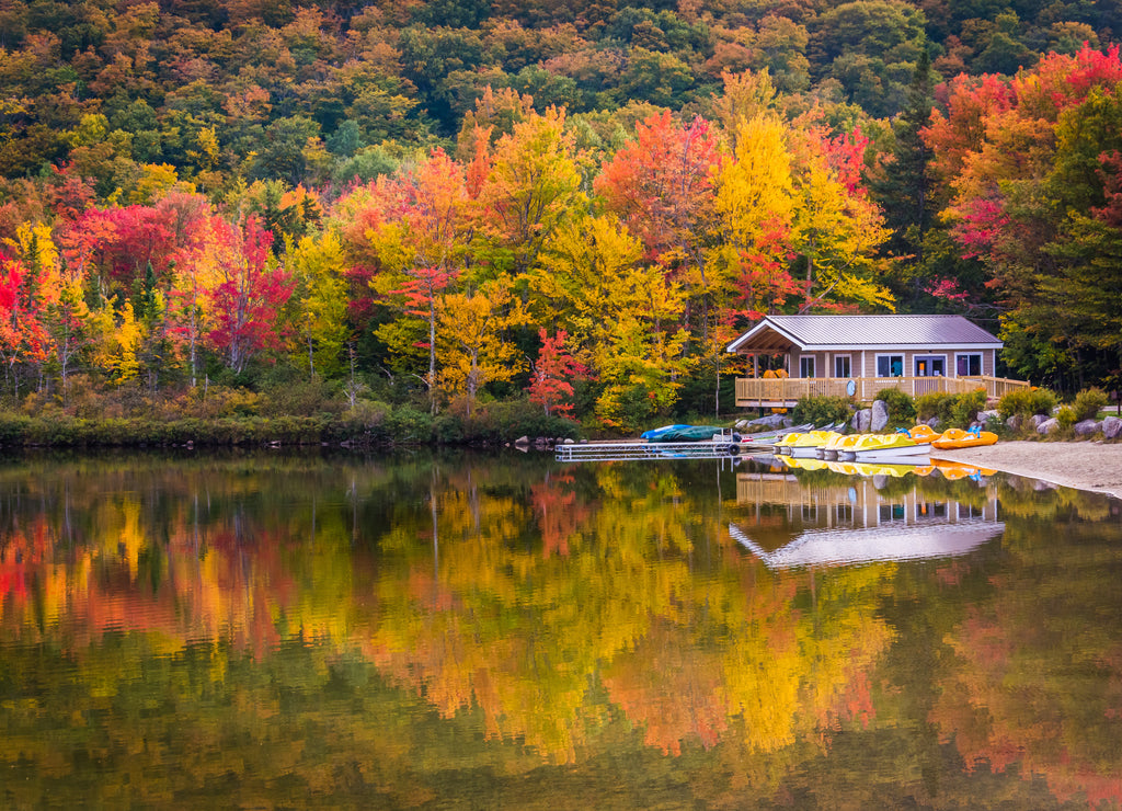 Boathouse and fall colors reflecting in Echo Lake, in Franconia, New Hampshire