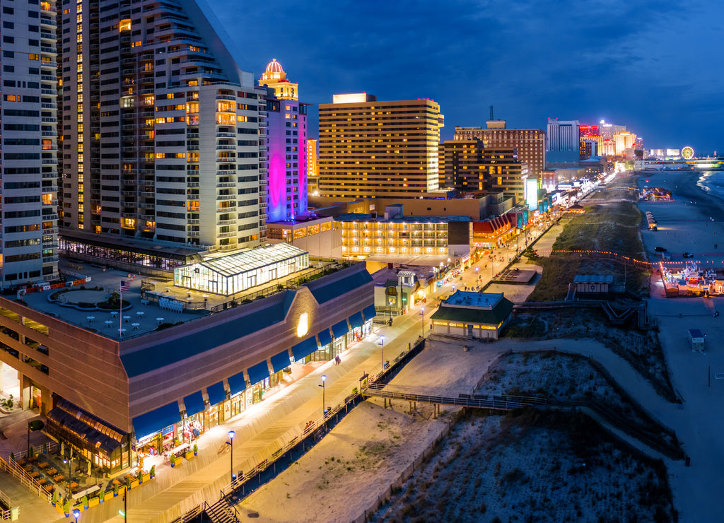 Aerial panorama of Atlantic city along the boardwalk at dusk. In the 1980s, Atlantic City achieved nationwide attention as a gambling resort and currently has nine large casinos, New Jersey