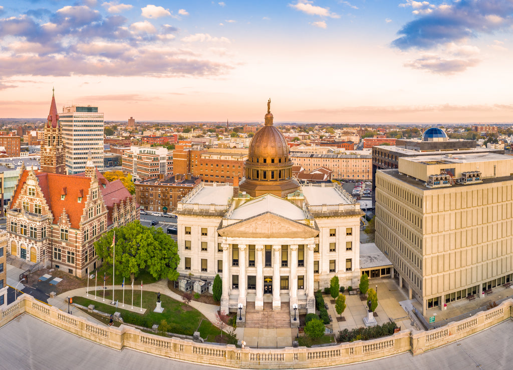 Aerial cityscape of Paterson, New Jersey at sunset. Three public buildings dominate the skyline: Passaic County Court House Annnex, Historic Court House and Passaic County Superior Court