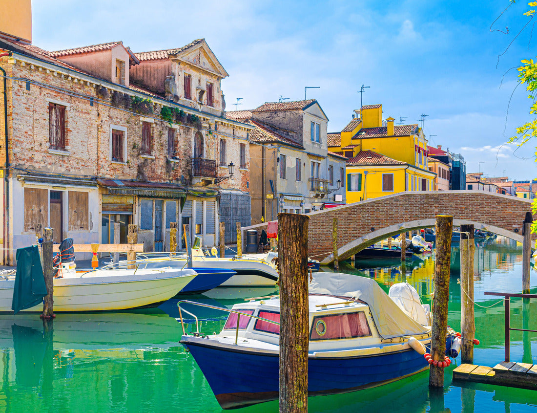 Noah Jigsaw Puzzle Chioggia cityscape with narrow water canal with colorful multicolored boats and yachts between old colorful buildings and brick bridge, blue sky background in summer, Veneto region, northern Italy 1000 pieces