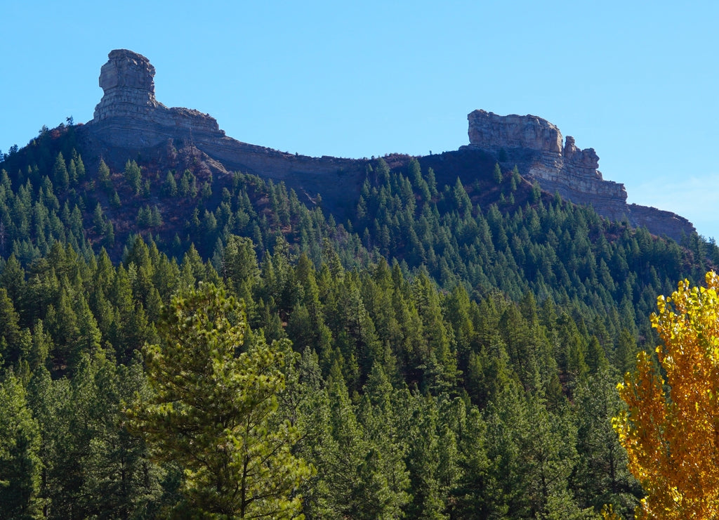 A beautiful mountain in Pagosa Springs, Colorado has a thick forest covering it's sides, and Chimney Rock on it's top