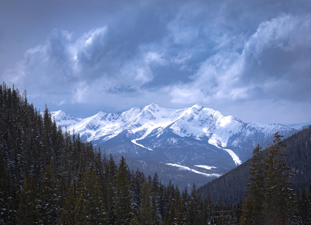 Snowy cloudy mountain peak landscape with evergreen tree forest in Arapaho National Forest, Colorado