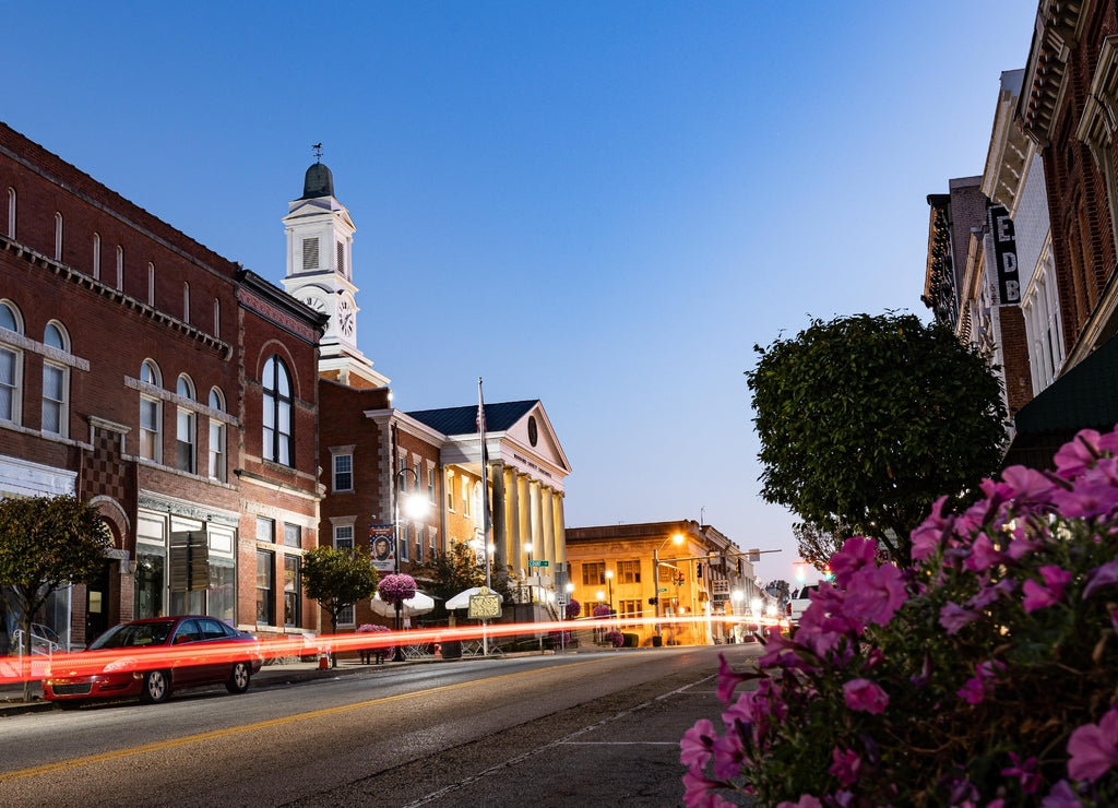 Taillight trails of the traffic on Main Street in downtown Versailles, KY during early morning just before sunrise in front of Woodford county courthouse