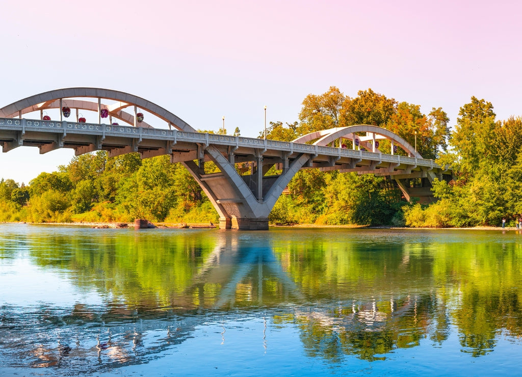 Rogue River Bridge, spanning Redwood Highway 25 in Grants Pass, Josephine County, Oregon. The arching bridge reflected on Rougue River at sunset