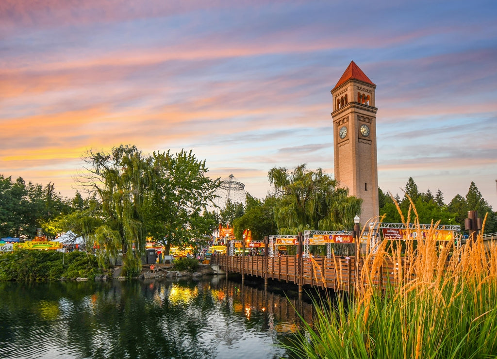 Festival goers enjoy a colorful sunset at the annual Pig out in the Park at Riverfront Park along the Spokane River in Spokane, Washington