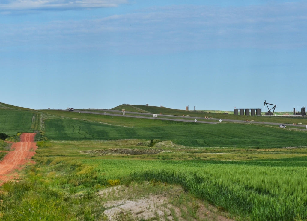 Oil Pumps in Farm Fields along Road near Dickinson North Dakota on a Sunny Day
