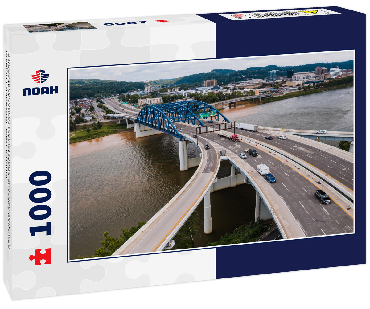 This is an aerial of a blue, eight-lane highway arch bridge that carries Interstate 64 over the Kanawha River in Charleston, West Virginia