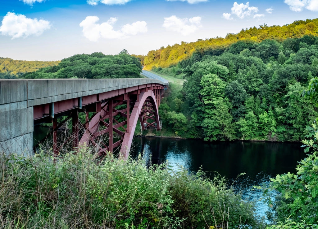 Bridge going over the Clarion River near Clarion, Pennsylvania, not far from the Allegheny National Forest. Green Trees, Bridge over the river and bright blue cloud filled sky in the background