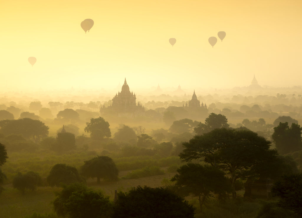 Hot air balloons fly over the pagoda ancient city field on silhouette sunrise scene at Bagan Myanmar