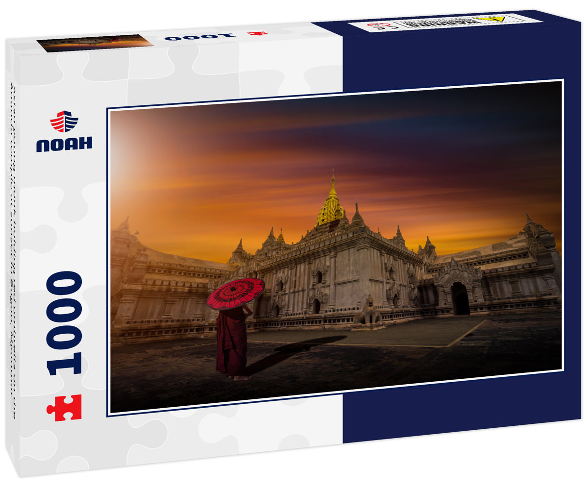 Asian young monk holding red umbrella on the Ananda temple at sunset in Bagan, Myanmar