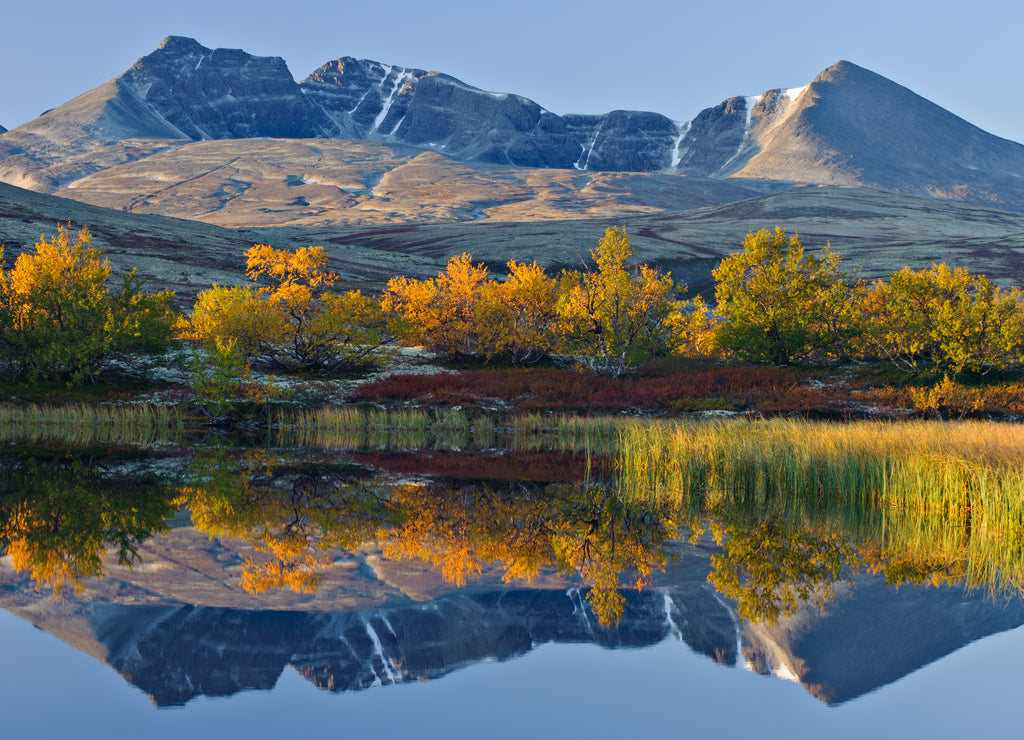 Reflection of Rondslottet mountain in a small lake. Rondane National park, Norway